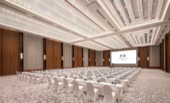A spacious ballroom is arranged with tables and chairs for an event at Junluxe Guangzhou Baiyun