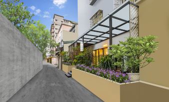 There is an apartment building with plants and flowers on the sidewalk in front at Yue City Youth Apartment