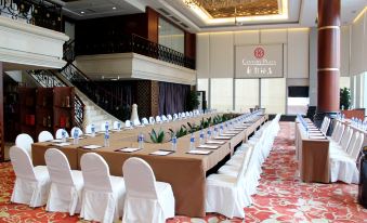 a large room arranged with long tables and chairs facing the front for an event at Century Plaza Hotel