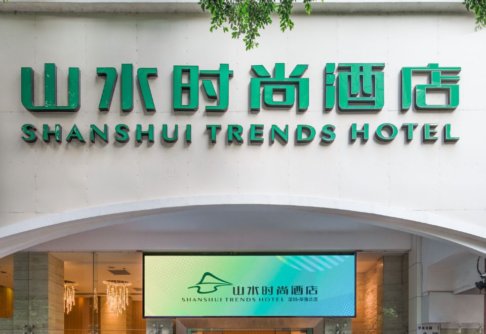 The front entrance of a restaurant features a sign above it and an illuminated clock on top at Shanshui Trends Hotel (Shenzhen Huaqiangbei)