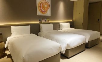 In the bedroom, there are two beds with clean linens placed on the bedside tables at Novotel Shanghai Clover