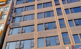 The hotel in an urban setting features a front view and side facade with large windows at Yizhi Hotel