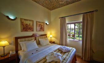 a cozy bedroom with a large bed and a window , providing a view of the outdoors at Vila Alba Resort