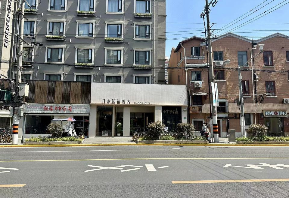 There is a large building with people walking down the street in front and on either side at Jimu Xiaozhu Hotel (Shanghai Jing'an Temple)