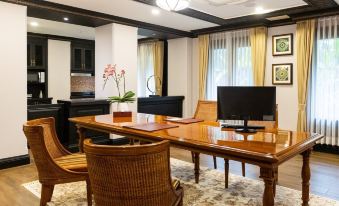 a dining room with a wooden table , chairs , and a television mounted on the wall at Lanna Resort Chiang Mai