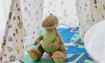 A stuffed animal is sitting in the bathroom, surrounded by other toys at Grand Millennium Shanghai HongQiao