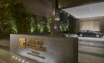 The entrance to a hotel features large windows and an illuminated sign on the wall at Holiday Inn Golden Mile