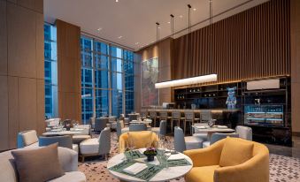 The restaurant offers a spacious interior with tables and chairs, providing a panoramic view of the city at Junluxe Guangzhou Baiyun
