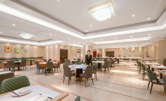 The restaurant features large tablecloths and wooden paneling on its dining room tables at Vienna International Hotel (Shanghai Pudong Airport)