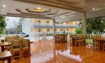 a large , well - lit room with a tiled floor and several wooden tables and chairs arranged for meetings or events at Funwan Hotel