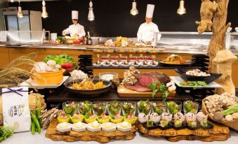 a buffet table with a variety of food items , including meat , vegetables , and desserts , as well as chefs preparing dishes at Naeba Prince Hotel