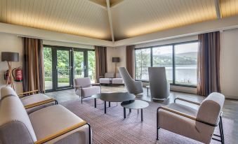 a spacious living room with various seating options , including couches , chairs , and a dining table at The Kenmore Club