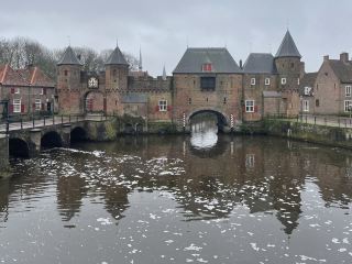 Amersfoort is a historic city in the province of Utrecht in the central Netherlands, located between Amsterdam and Utrecht, with a population of approximately 158,000. Its history dates back to the 11th century, and it gained city rights in the 13th century, gradually developing during the Middle Ages due to textiles, brewing, and trade. The old town still retains its complete medieval city layout, along with numerous historical buildings and canal landscapes. The Koppelpoort, built in the 15th century, is one of the few well-preserved medieval amphibious city gates in the Netherlands, used for both land defense and waterway control. It is Amersfoort's most representative historical building and is considered a model of the Dutch medieval defensive system. The Our Lady Tower, approximately 98 meters high, is one of the tallest medieval church towers in the Netherlands and a landmark of the city. Climbing to the top offers panoramic views of the old town and surrounding area. The Freit Museum, located within the historic buildings, primarily showcases the history, art, and cultural development of the Amersfoort region.