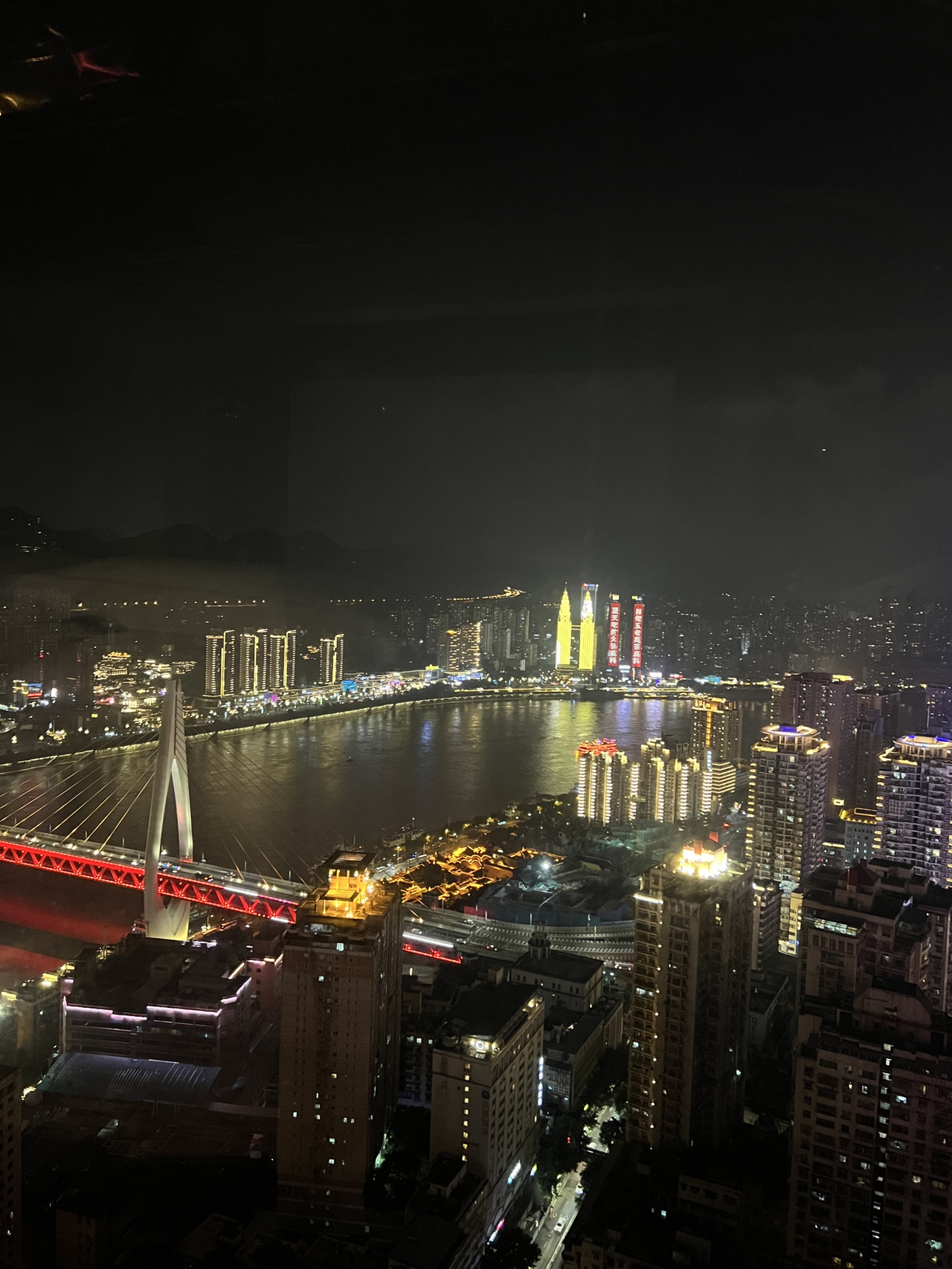 📍 Gambaran Itinerary
Chongqing, yang dikenal sebagai "Kota Gunung" di Tiongkok, terkenal dengan bukit-bukit curamnya, pemandangan sungai yang dramatis, masakan pedas, dan pemandangan malam yang memukau. Dengan geografi unik di mana gedung pencakar langit berdiri di atas tebing dan kereta melintasi bangunan, berkeliling kota ini adalah bagian dari petualangan itu sendiri.

🚩 Rute Wisata
Hari 1 – Sorotan Kota
• Pagi: Mulailah di Jiefangbei Pedestrian Street, pusat komersial kota.
• Siang: Jelajahi Hongya Cave, kompleks rumah panggung di tepi sungai dengan toko dan tempat makan.
• Malam: Naik kapal pesiar malam di Sungai Yangtze untuk mengagumi cakrawala Chongqing yang diterangi lampu.

Hari 2 – Budaya & Pemandangan
• Pagi: Kunjungi Ciqikou Ancient Town, jalan tua yang terawat baik dengan rumah teh dan kerajinan tangan.
• Siang: Naik Kereta Gantung Sungai Yangtze yang ikonik untuk menikmati pemandangan panorama.
• Malam: Pergi ke Nanbin Road atau Eling Park untuk melihat pemandangan kota dan fotografi matahari terbenam.

🏖️ Tempat Wisata Wajib
• Hongya Cave – kompleks tebing ikonik yang diterangi lampu di malam hari.
• Kereta Gantung Sungai Yangtze – transportasi sekaligus atraksi yang wajib dicoba.
• Ciqikou Ancient Town – sekilas budaya Chongqing di masa lalu.
• Museum Tiga Ngarai – sejarah dan budaya wilayah Sungai Yangtze.
• Eling Park & Nanbin Road – pemandangan kota terbaik.

🚇 Transportasi
• Sistem Metro: Chongqing Rail Transit (CRT) luas dan efisien, menghubungkan sebagian besar tempat wisata. Jalur 2 & 3 memiliki pemandangan indah, terutama Jalur 2 yang melintasi bangunan.
• Kereta Gantung: Kereta Gantung Sungai Yangtze berfungsi sebagai transportasi sekaligus atraksi.
• Bus: Tersedia secara luas tetapi menantang bagi yang tidak berbicara bahasa Tiongkok.
• Taksi & Aplikasi Ride-Hailing: Didi sangat berguna; taksi terjangkau tetapi harap bersiap menghadapi kemacetan di jam sibuk.
• Jalan Kaki: Bersiaplah untuk mendaki bukit dan tangga—bagian dari pengalaman Chongqing.

📷 Spot Foto
• Jiefangbei di malam hari (cakrawala modern yang ramai).
• Raffles City Chongqing (arsitektur futuristik di Chaotianmen).

🍜 Masakan Lokal
• Hotpot Chongqing – pedas, menggigit, dan ikonik.
• Xiao Mian (mie Chongqing) – sarapan sederhana namun penuh rasa.
• Laziji (ayam pedas dengan cabai & merica) – berani dan adiktif.
• Suancaiyu (sup ikan asam) – hidangan ikan yang asam dan pedas.
• Sate panggang & camilan jalanan – sempurna di Ciqikou atau pasar malam lokal.

✨ Berkeliling Chongqing sama serunya dengan tempat-tempat wisata itu sendiri—baik itu naik jalur metro yang melintasi gedung pencakar langit, meluncur melintasi Sungai Yangtze dengan kereta gantung, atau mendaki tangga tersembunyi yang menghubungkan "Kota Gunung." 