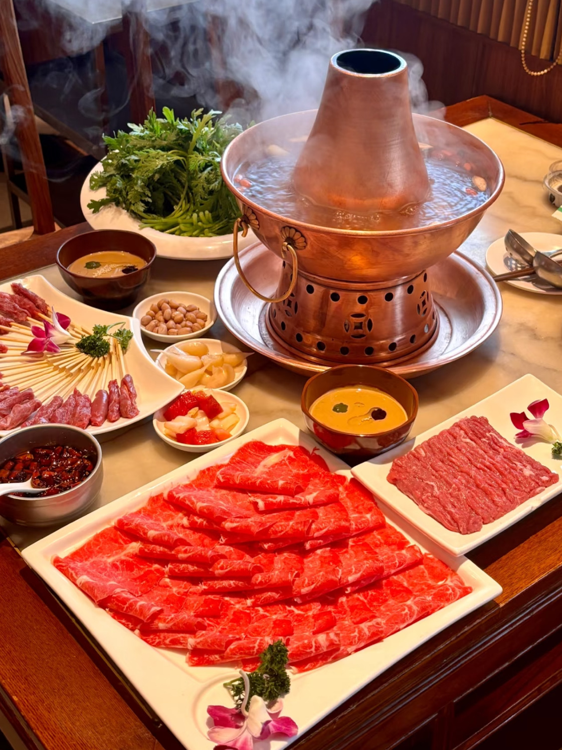 #hellohalloween

Jika Anda ingin menikmati hotpot tembaga ala Beijing yang autentik, tempat di tepi Danau Shichahai ini wajib dikunjungi! Saya mengajak seorang teman ke sini, dan kami berdua pulang dengan sangat puas — terutama karena kami beruntung mendapatkan tempat duduk di dekat jendela dengan pemandangan danau. Menyaksikan pemandangan musim semi sambil hotpot mendidih? Sempurna. 🌸

Tempat ini telah menjadi favorit keluarga sejak saya masih kecil — kami selalu menyukai bakpao daging sapi, domba, dan wijen mereka, dan kualitasnya tidak pernah mengecewakan. Semuanya terasa segar dan kaya rasa, persis seperti hotpot Beijing klasik.

🔥 Hidangan wajib pesan:
• Kaki domba iris segar 🐑
• Babat sapi segar 🐄
• Acar bawang putih manis 🧄
• Roti pipih wijen panggang (烧饼) 🥯

Saus wijennya patut diacungi jempol — kental, kaya rasa, dan seimbang sempurna, menyatukan semua rasa.

💡 Tips:
Jika Anda datang saat akhir pekan atau hari libur, tempat ini bisa ramai. Ambil nomor antrean terlebih dahulu, lalu jalan-jalan di sekitar Jalan Yandai Xiejie atau Danau Shichahai sambil menunggu — saat Anda kembali, meja Anda kemungkinan besar sudah siap!

📍 Alamat: No. 2 Qianhai East Extension, Distrik Xicheng, Beijing
🚇 Stasiun Subway terdekat: Stasiun Shichahai, Pintu Keluar A2 (Barat Laut)

🍲 Kesimpulan: Hotpot klasik Beijing, cita rasa yang tak tertandingi, dan pemandangan yang lebih indah — benar-benar makanan favorit saya di Shichahai! ❤️