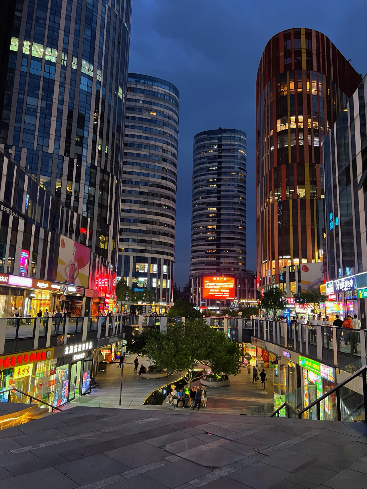 🌃 Sanlitun gets even more charming after dark.

If you want to experience Beijing's vibrant and modern side, try taking an evening stroll through Sanlitun ✨ This lively neighborhood brings shops, restaurants, cafes, and great pedestrian walkways all together in one place. The atmosphere is bustling yet totally enjoyable. As the sky gets darker, the glowing lights from buildings and storefronts really bring the city to life.

Personally, I love exploring here without a set itinerary 😊 You can stop for some great food, do a little shopping, snap some photos, and just sit back to people-watch. It’s the kind of neighborhood that reminds you Beijing isn’t just about historical landmarks—its modern cityscapes are just as incredible to explore 🌆💙

The evening is honestly the perfect time to visit 🌙 The weather cools down, and you'll see more people out dining and shopping. The whole area is buzzing with energy and bright lights. If you're into nighttime city photography, I’d suggest carving out 1–2 hours just to wander. Every corner offers a different visual and vibe. Taking your time and strolling at a relaxed pace is such a fun experience 📸✨