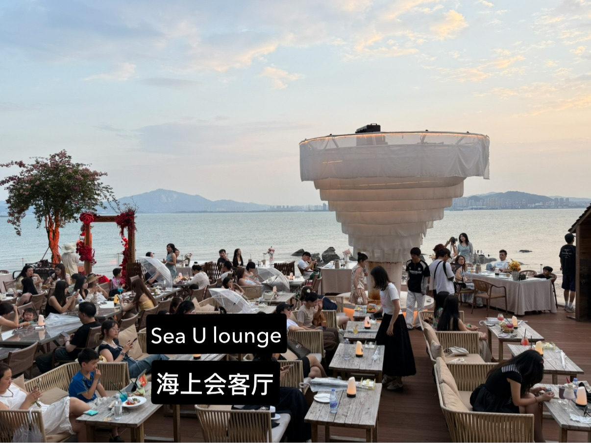 When people think of Xiamen, iconic attractions such as Gulangyu Island and Zhongshan Road Pedestrian Street often come to mind. However, one of the city’s most enjoyable experiences is spending an evening at Sea U Lounge (海上会客厅), a stylish waterfront venue where visitors can unwind while taking in panoramic views of the harbor and skyline.

Why Visit Sea U Lounge?

Sea U Lounge offers a different side of Xiamen. Rather than rushing between attractions, this is a place to slow down and appreciate the city’s maritime charm. Situated along the waterfront, the lounge provides uninterrupted views of the sea, passing ferries, and the glittering lights of the city after dark.

Whether you’re a photographer, a couple looking for a romantic evening, or simply a traveler wanting to escape the crowds, Sea U Lounge delivers one of the most memorable sunset experiences in Xiamen.

What to Expect

As evening approaches, visitors gather on the outdoor deck to watch the changing colors of the sky. The setting sun paints the harbor in shades of gold and orange, while ferries glide across the water towards Gulangyu Island.

Once night falls, the atmosphere transforms completely. The skyline lights up, reflections dance across the water, and the waterfront comes alive with a sophisticated yet relaxed vibe. Grab a drink, find a seat overlooking the sea, and enjoy one of the best nighttime views in the city.

Best Time to Visit

Sunset Session (Recommended)

· Arrive around 5:30 PM
· Secure a seat with a clear waterfront view
· Watch the sunset over the harbor
· Stay for the transition into the evening cityscape

Evening Session

· Visit after 7:00 PM
· Enjoy illuminated buildings and harbor lights
· Perfect for photography and a leisurely night out

Photography Tips
📸 Sunset usually offers the most dramatic photographs, especially when ferries are crossing the water.

📸 Stay after dark to capture long-exposure shots of the city lights reflecting on the sea.

📸 The best images often combine the waterfront deck, skyline, and passing boats in a single frame.

Final Thoughts

Xiamen is often praised for its relaxed coastal atmosphere, and Sea U Lounge embodies exactly that. While famous landmarks showcase the city’s history and culture, this waterfront hideaway offers something equally valuable: a chance to sit back, enjoy the sea breeze, and watch the city come alive as day turns into night.
🌅✨