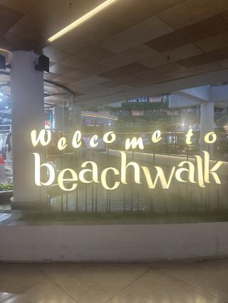 My Honest Take on Beachwalk, Kuta
I stumbled into Beachwalk mostly to escape the midday heat and grab an iced coffee with AC. Turns out, it’s one of those places where you end up staying longer than planned.
What I Liked 🫶🏻
· Ocean views. The mall sits right across Kuta Beach. There’s an open terrace on the top floor - I sat there with a latte and watched the sunset. That’s the highlight.
· Brands. Inside you’ll find H&M, Uniqlo, Zara, Sephora, Cotton On, and plenty of local boutiques. Prices are higher than at markets, but everything’s authentic and sizes are reliable.
· Food. The third-floor food court has a solid mix of Asian and Western options. I had pad thai and a smoothie - tasty and affordable. There are also sit-down restaurants with views, but they’re pricier.
· Vibe. Open-air design, lots of greenery, background music, people-watching. It feels like a leisure spot, not just a shopping mall.
📍My Tips
· When to go: After 4 PM — less heat, chance to catch sunset.
· How long to spend: 1.5–3 hours if you want to shop, eat, and just hang out.
· Getting there: From anywhere in Kuta, it’s a 5–10 minute taxi or scooter ride. Parking is paid (around 2–5k IDR per hour).
✅ Bottom Line: 
Beachwalk isn’t a must-visit, but if you’re in Kuta and want AC, branded shops, and an ocean view, it’s worth a stop. I wouldn’t make a special trip, but as part of a Kuta walk - totally fine.
Address: Jl. Pantai Kuta, Kuta, Badung, Bali 80361, Indonesia 