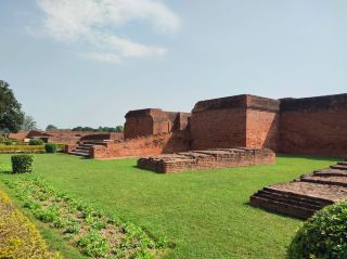 Nalanda University: The oldest center of Buddhist learning in the world.

The ancient Nalanda University site is located in Nalanda, Bihar, India. It comprises stupas, ancient buildings, and ruins of brick and mortar that still indicate its past prosperity, particularly its role as the largest and oldest center of Buddhist education in the world. Today, the most important and magnificent structure is the Sariputra Stupa, which contains relics of the Venerable Sariputra and is revered by Buddhists. The stupa is constructed of red brick, is very large, and is the most prominent of all the stupas in the area. Many smaller stupas and structures surround the large main stupa. The main stupa has stairs leading up, indicating that access to the upper levels was possible in the past, but it is now closed due to safety barriers. Near the main stupa are the living quarters used by monks and the place of study in the past. The current state of the Nalanda University site is filled with lush green gardens, many large trees of various species, and some areas are planted with beautiful flowers. There is also a small lotus pond. The ancient site is very clean and peaceful. Even with frequent tourists, it always feels serene. For transportation, private car or a guided tour is recommended for convenience. Nalanda is approximately 80 kilometers from Bodh Gaya. Additional recommendation: Nalanda is near Rajgir. If you have time, you can also visit many important places in Rajgir, such as Veluvana Temple, the first Buddhist temple, or Kichchhakuta Hill, etc.

#TravelIndia #TravelAbroad #India #Nalanda #Prayers
