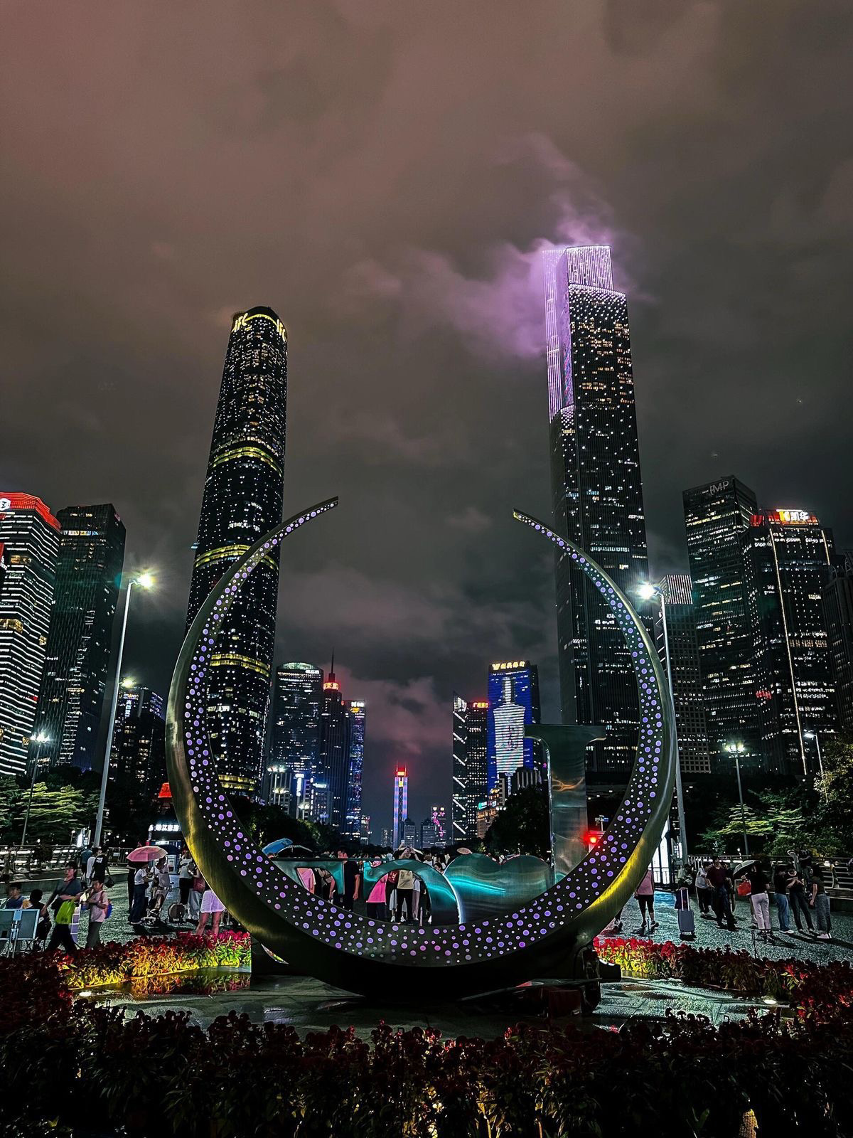 Mengalami Guangzhou di malam hari seperti melangkah ke dalam lukisan hidup yang penuh dengan cahaya dan arsitektur. Gedung-gedung pencakar langit yang tinggi bersinar indah di bawah langit gelap, setiap bangunan dihiasi dengan pola warna-warni dan pantulan yang berkilauan di Sungai Mutiara. Kota ini terasa hidup dengan energi, memadukan desain modern dengan pesona budaya. Berjalan di tepi sungai atau memandang dari titik pandang yang tinggi, pemandangan malam yang menakjubkan meninggalkan kesan mendalam tentang Guangzhou sebagai salah satu kota paling hidup dan mempesona di Tiongkok. 🌟🏙️🌉