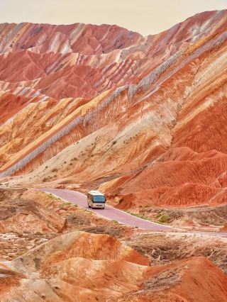 Spectacular Rainbow Landscapes at Zhangye Danxia National Geological Park 🌈🏔️  
Prepare to be wowed by nature’s palette—Zhangye Danxia puts on a display of rainbow-colored hills that look almost unreal, like Mother Earth’s own painted canvas! This is one of China’s most famous geological wonders and an absolute bucket-list photo spot.  

🧭 Recommended Route:
Start at the main entrance early to beat the crowds. Take the park shuttle bus, which loops between all four main viewpoints: Binggou, Qicai (the classic “Sunset Hill”), Yuguang, and Danxia Scenic Area. Try to catch both sunrise and sunset if you can; the colors really pop at these golden hours.  

📸 Must-Do Activities & Top Photo Spots:
Hike up to Platform 1 and Platform 4 for wide-angle shots of the most vibrant ridges. The “Rainbow Ridges” near Qicai Viewing Platform are the most iconic (your insta-feed will thank you!). Don’t miss the natural stone formations at Binggou—crisp morning light here makes for surreal photos.  

💡 Visiting Tips:
· Best season: June to September, when colors are boldest post-rain.
· Bring a hat, sunscreen, and lots of water—shade is rare and it gets HOT.
· Photography tip: Bring a polarizer filter to deepen those blues and reds.
· The park is sprawling, so allow at least half a day, or longer if you’re catching both sunrise and sunset.
· Facilities are basic—carry snacks, and don’t expect fancy cafés.  

⚠️ Key Precautions:
Paths and platforms are mostly safe but can be slippery after rain, so wear sturdy shoes. Watch your step, especially near cliff edges—those jaw-dropping views come with height!  

#zhangye  #danxia  #rainbowmountains  #chinatravel  #photospot 