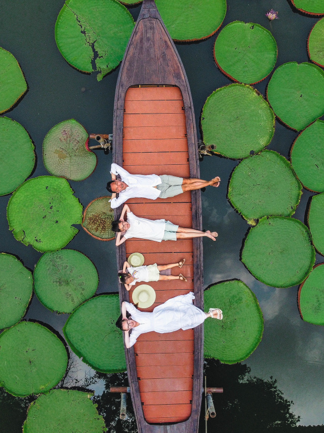 I want to share this beautiful place😍
⠀
This is a cafe: Ma Doo Bua Cafe📌
➖This cafe is famous for its stunning pond with giant water lilies and charming wooden houses. Overall, it's an incredibly cool and photogenic place❤️
This location isn't very well-known among tourists because it's not included in standard tours, but it is featured in tours like "Secret Places of Phuket."
⠀
🔸We booked a taxi from our hotel🚕.
When you arrive, you'll immediately see a counter with pricing for photos and videos🙂.
I'll attach the price list in the carousel✔️
🔸We chose the family photo + video package😍
It cost us approximately 5000₽.
You'll be added to a queue based on time.
Yes, there is a queue😅. We knew there could be long waits, so we arrived at 9:30 AM, although the location itself is open from 10:00 AM to 6:00 PM.
We were listed as number 5 in the queue and were scheduled for 10:40 AM. However, we were called earlier, possibly because of the kids.
🔸You select your package and pay at the entrance, receive tickets, and are invited to wait in the cafe.
You can grab a bite while waiting🙂
🔸The place itself isn't very large, but it's incredibly beautiful😻🪷. It feels like stepping into a serene Thai village. Surrounding the pond are rows of traditional Thai wooden houses with pointed roofs. The pond is home to Victoria Amazonica—the largest water lily in the world.
There's also a bridge where you can take photos and record videos on your phone.
Access to the boat is ticket-based only.
🔸When your turn comes, you'll be invited.
The boat is cleaned after each visitor, and towels are placed for comfortable lying🙂. They're arranged in a way that they're barely visible in photos and videos👍.
🔸The footage is shot by Thai professionals using a drone.
They guide you on how to pose and what to do.
They adjust your position each time😃 and fix your clothing. It's clear they're experienced videographers👍.
🔸The content is sent directly to your phone📱. Very convenient👍.
🔸The session doesn't take long, probably around 15 minutes.
⠀
An excellent spot for photoshoots and enjoying aesthetic pleasure🌴.