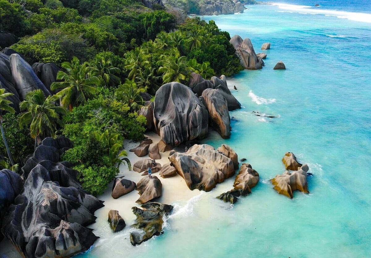 🏝️Expectations vs. Reality: How We Visited the Most Beautiful Beach on the Planet, Anse Source d'Argent

Anse Source d'Argent Beach on La Digue Island is perhaps the main reason to fly to the Seychelles. We really wanted to see those advertised pink granite boulders, and the reality did not disappoint!

The landscape here is truly celestial, with cliffs dividing the coastline into several cozy, secluded coves.
But this paradise has its own nuances, which are best known in advance. The beach is located within the old L'Union Estate park, so we paid about 150 rupees per person for the day's admission.

Getting here was quite a quest. First, we took a ferry from Mahé to Praslin, from there we took a boat to La Digue, and once on the island, we rented bicycles right at the pier. There are almost no cars there, so pedaling downhill is an adventure in itself.

The most important tip: be sure to check the tide schedule! We arrived at low tide for the first time—the water had receded so far that the ocean had turned into a shallow puddle, revealing the coral. We weren't able to swim, but we did wade knee-deep in the clear water and admire the colorful fish right at our feet. If you want to swim, choose high tide and be sure to bring coral slippers to avoid cutting your feet.
There are a lot of tourists here.

To get those epic shots without the crowds in the background, we arrived by bike at 8:30 am. At this time, the light is still soft, and it was just us and a couple of local guides on the beach.
I highly recommend renting a clear kayak right on the shore. The photos from the water against these giant rocks are simply incredible. This place is definitely worth it!

Subscribe ✅
I'll try to share as many life hacks as possible with you. I'd love to hear from everyone 😊

#seychelles #mahe #ladig