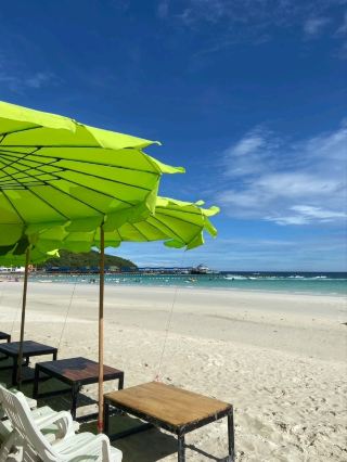 "A white sandy beach with clear water, perfect for swimming and spending the whole day in the water.