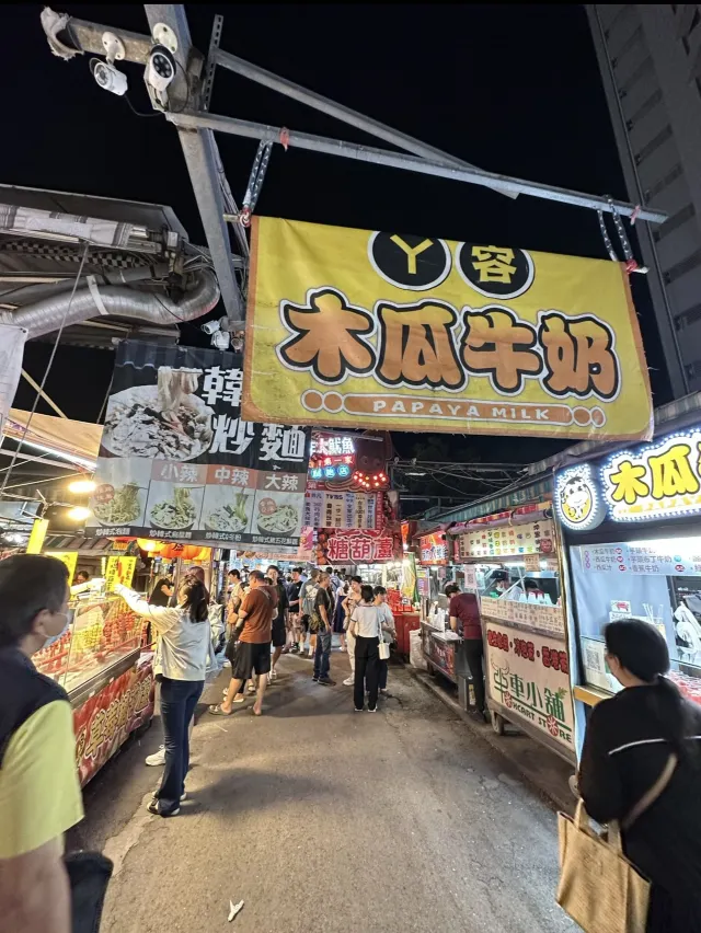 瑞豐夜市街景：木瓜牛奶與炒麵攤的招牌沿著排數一路延伸，人潮絡繹不絕