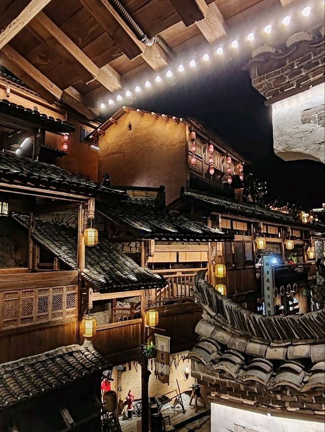 Wangxian Valley: Night Market Lights Reflecting Visitors