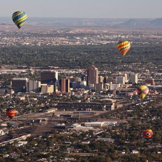I recently spent a couple of days in Albuquerque, New Mexico. Coming from humid Hong Kong, the dry, thin air here at 1,600 metres was a real system shock—I had to double my water intake and apply lip balm constantly. But as someone who works in exhibition curation, the museums and historical spots here were incredibly fascinating, and the retro aesthetic of the city felt surprisingly nostalgic.

Here is a detailed breakdown of how I spent my two days, mostly getting around by rideshares.

· *Day 1: Balloon History, Pueblo Art & Retro Neon**
I started around 8:40 AM, taking a 20-minute Uber from my hotel near Old Town to the Anderson-Abruzzo Albuquerque International Balloon Museum (entry was USD 7). Being a curation assistant, I really appreciated how they laid out the history of hot air balloons and early flight gear. It wasn’t crowded on a Thursday morning, so I could take my time browsing the vintage baskets and historical footage.

By late morning, I headed to Old Town to see the historic adobe buildings and the San Felipe de Neri Church. It has a very distinct Spanish-Pueblo charm, though the tourist crowds were starting to build up. Afterward, I visited the Indian Pueblo Cultural Center (USD 12). If you go, definitely plan to have lunch at their on-site restaurant. I tried the local dishes featuring their famous red and green chilies—quite spicy but very unique. The restaurant gets busy, so prepare to wait a bit for a table.

In the afternoon, I stopped by the New Mexico Museum of Natural History and Science (USD 14) to see the dinosaur fossils, before heading to Nob Hill along Route 66 for sunset. The vintage neon signs lighting up at dusk had this amazing, nostalgic late-80s aesthetic. It honestly felt like stepping into a scene from *Cowboy Bebop* or some classic retro sci-fi anime.

· *Day 2: Volcanic Rocks, Cold War History & A Windy Mountain Peak**
I started early at 8:15 AM to beat the sun, taking an Uber to the Petroglyph National Monument (Piedras Marcadas Canyon). Walking among the black volcanic rocks to spot the ancient petroglyphs carved by Native Americans and early Spanish settlers was incredibly peaceful. Just a heads up: there are absolutely no shops or shade along the trail, so you must bring your own water.

Next was the National Museum of Nuclear Science & History (USD 22). The exhibition on the Manhattan Project and Cold War technology was deeply fascinating, if a bit sobering. Seeing the decommissioned bomber planes and rockets in the outdoor exhibition area reminded me of the post-apocalyptic settings in some of the sci-fi anime and mobile games I play at home.

The highlight of the afternoon was the Sandia Peak Tramway (USD 35 for a round trip). It takes about 30 minutes to get there from the city. The cable car takes you up to over 3,200 metres. A word of warning: the weather at the top is completely different from the city. It was incredibly windy and easily 10 to 15 degrees colder. I was shivering in my light jacket, so definitely pack a proper windbreaker. Also, check their website before going, as they close for maintenance on Tuesdays or when the winds are too strong.

· *Some practical details if you’re planning a trip:**
· **Transportation:** I relied on Uber. It's doable, but since the spots are quite spread out (especially the Tramway and the Nuclear Museum), expect to wait 5–10 minutes for a ride to accept. If you can drive, renting a car might save you some waiting time.
· **Altitude & Weather:** Drink water constantly. The sun is intense, and the air is very dry. 
· **Closures:** Keep in mind that some places have specific rest days (like the Balloon Museum on Mondays, and the Tramway usually on Tuesdays). Plan your itinerary carefully so you don't end up facing closed doors.

It was a relatively quiet, low-key trip, but the unique blend of desert nature and retro-futuristic history made it well worth the long flight.