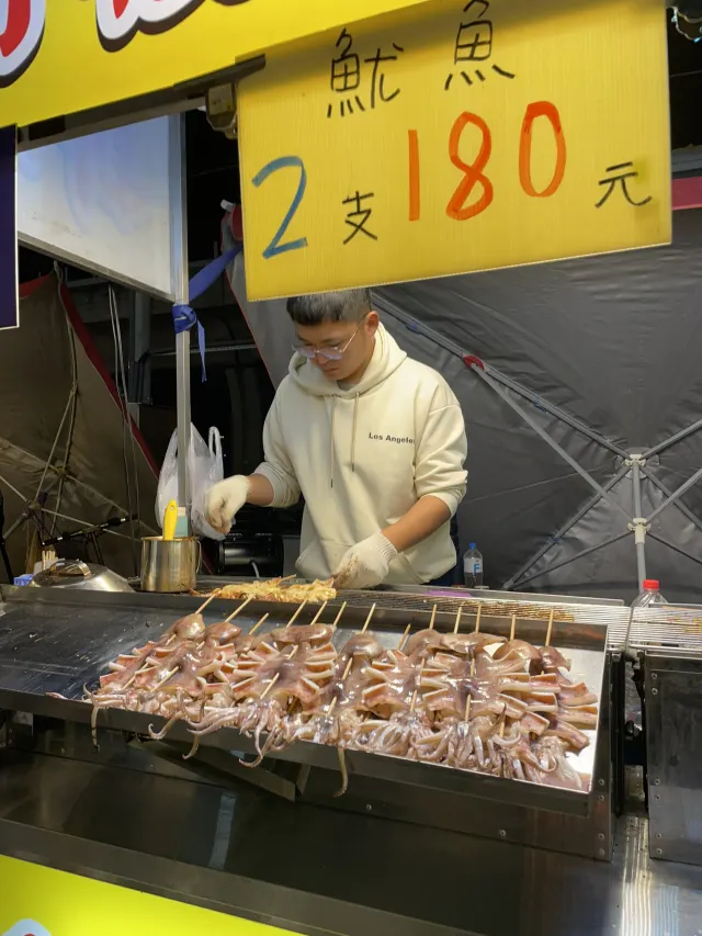 大慶夜市現烤魷魚攤位,攤商正在烤台上翻烤魷魚
