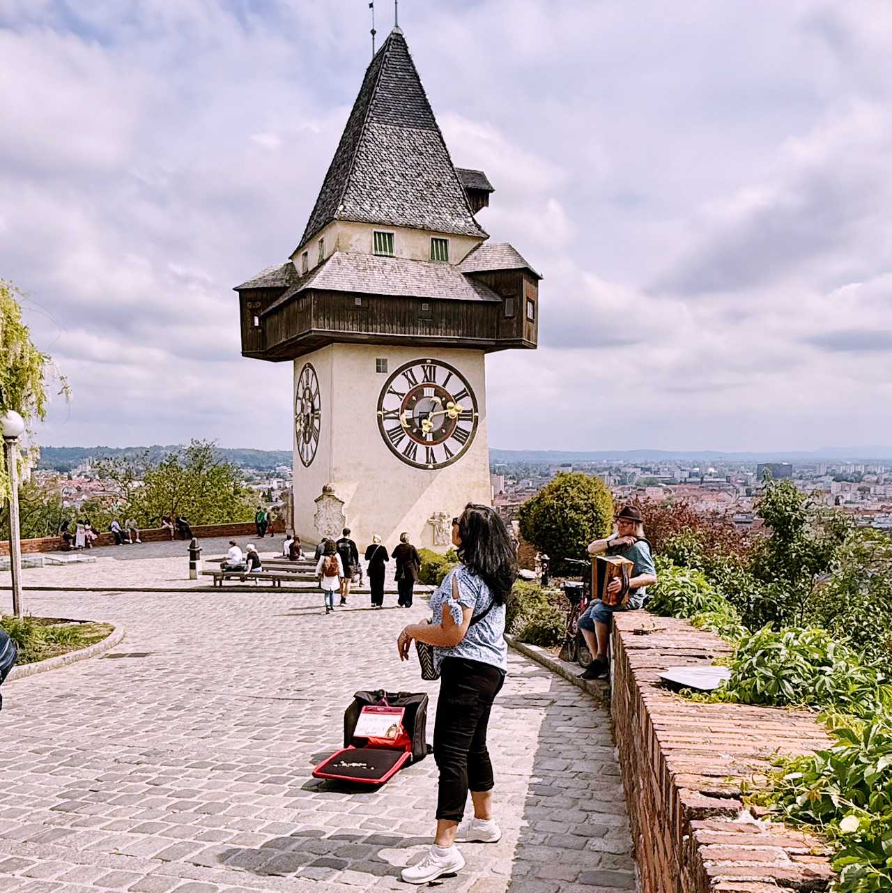 Exploring Graz’s Iconic Uhrturm: Best Views & Local Vibes 🔥🌄  
If you’re in Graz, don’t miss the legendary Uhrturm (clock tower) perched up on Schlossberg hill. This spot delivers major wow-factor panoramas — and it’s epic for travelers of all ages. My favorite moment? Watching a child gaze out over the city, framed by Western-style architecture and lush mountain greenery, even with the weather flipping from cloudy to sunny and rainy. The mix of historic buildings and sleek modern facades is a cool surprise!

Must-See Spot in Graz  
▫️ Uhrturm (Am Schlossberg, 8010 Graz, Austria) — Open all year: 00:00–23:59  
▪️ The climb up Schlossberg is a workout but totally doable; you can use the stairs, take the Schlossbergbahn funicular, or ride the glass lift for awesome city views through the trees.  
▪️ Rain or shine, the scenery’s always Insta-worthy — don’t let the weather hold you back! Graz looks stunning in every mood.

Tips & Tricks:  
▫️ Go early in the day for fewer crowds.
▫️ Bring snacks and water, there’s plenty of space to sit for a picnic with a city backdrop.
▫️ Weather changes quick! Pack an umbrella or light jacket.  
▫️ For families: Kids love the Uhrturm’s huge clock faces & the view from the hilltop!

Getting Around: Graz has solid public transport, but Schlossberg is central so it’s an easy walk. For quick city moves, local buses and trams are efficient.

Foodie Tip: Grab a pastry or coffee at a café near the base of Schlossberg before your climb. The area’s got tasty, local options.

#GrazViews #AustriaTravel #Uhrturm #FamilyExplorer #tripdotcom
