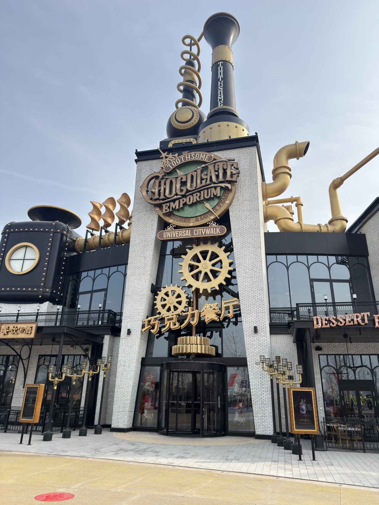 #OverseasTravel #Beijing
Toothsome Chocolate Emporium & Savory Feast Kitchen is one of the most ornate and striking restaurants at Universal Studios Beijing. From the entrance, its massive chocolate sculptures and steampunk-themed interior immediately catch the eye, making it easy to spot from afar. The atmosphere feels like stepping into a chocolate factory, offering countless photo opportunities.
While Toothsome Chocolate Emporium & Savory Feast Kitchen is renowned for its chocolate-infused desserts, the restaurant also offers a diverse menu. From Western dishes like steaks, burgers, and pasta to light brunch-style options, you can choose to suit your taste buds. The food is also beautifully presented, making it a feast for the eyes and the palate.
Their most popular item is the giant milkshake. The cup is overflowing with cake, cookies, and chocolate, creating a truly stunning visual treat. If you're a fan of sweets, this is a must-try. The generous portions make it perfect for sharing.
The interior is relatively comfortable, with high ceilings and ample seating. However, as it's a popular restaurant, there may be a wait during meal times. It's a great place to visit if you want to take a break from the rides and enjoy a sweet moment. I highly recommend it if you're looking for a unique dining experience at Beijing Universal.