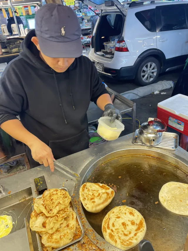 大慶夜市現擀現煎的餅類攤位,老闆正在鐵板上翻煎餅皮