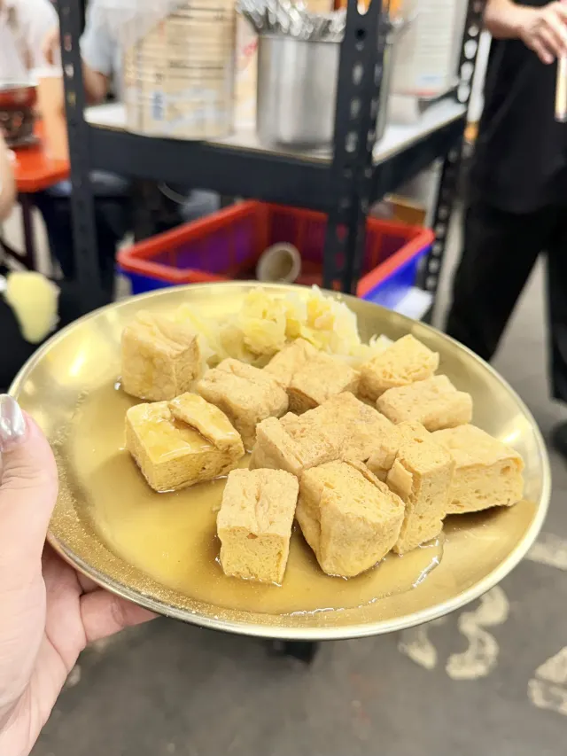 鐵盤上剛起鍋的炸臭豆腐，金黃方塊狀