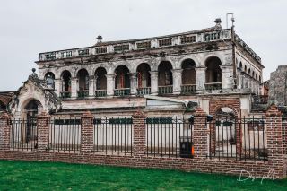 In Liuchuan Village, Jiaomei, Zhangzhou, a legendary building called Tianyi general office is hidden, predating the Great Qing China Post Office by 16 years.
1880, Guo Youpin, an overseas Chinese in the Philippines, founded the Tianyi remittance bureau, specializing in remittances between Minnan and Southeast Asia. It is the earliest recorded private international post office in China. At its peak, it had 26 branches in 8 Southeast Asian countries, with annual remittances totaling tens of millions of silver dollars, accounting for nearly two-thirds of Minnan's remittances.
Stepping into the former site, the fusion of Chinese and Western architecture is striking: the north building is an iconic Nanyang-style office, its exterior carved with angels, doves of peace, and a bicycling postman, blended with Chinese floral motifs; the Wannan building has a front half of red-brick traditional house and a rear half of Western architecture, with an acrostic couplet carved above the door; there is also the former private garden Taoyuan, complete with pavilions, terraces, rockeries, and fish ponds.
The name Tianyi is taken from "the harmony between heaven and humanity, becoming one," conveying the idea that the world is one family. This century-old building carries the emotions and integrity behind countless remittances that crossed the oceans.
· Address: Liuchuan Village, Jiaomei Town, Zhangzhou Taiwan Business Investment Zone (direct navigation)
· Opening status: renovation completed in 2026, officially open to visitors
· Highlights: north building (iconic Nanyang architecture), Wannan building (Chinese and Western fusion), Taoyuan (century-old private garden)
· Visitor tips: descendants of the Guo family still live in the complex. Please be respectful when visiting
  