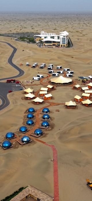 I still can’t get over the fact that they built this entire futuristic resort in the middle of nowhere. Those blue glass domes and aluminum houses in the dunes look unreal from above! 

📍save this to your Xinjiang bucket list. 

📝 Tips before you go:
1️⃣ Book in Advance: Desert luxury domes have limited capacity, especially during peak Xinjiang travel seasons.
2️⃣ Prep for Sand: Bring protective covers for your camera gear and drone the wind blows fine sand everywhere!
3️⃣ Pair it with: Spending a day in Makit town first to experience local culture before heading straight into the dunes.

📍N39° Taklamakan Desert, Xinjiang