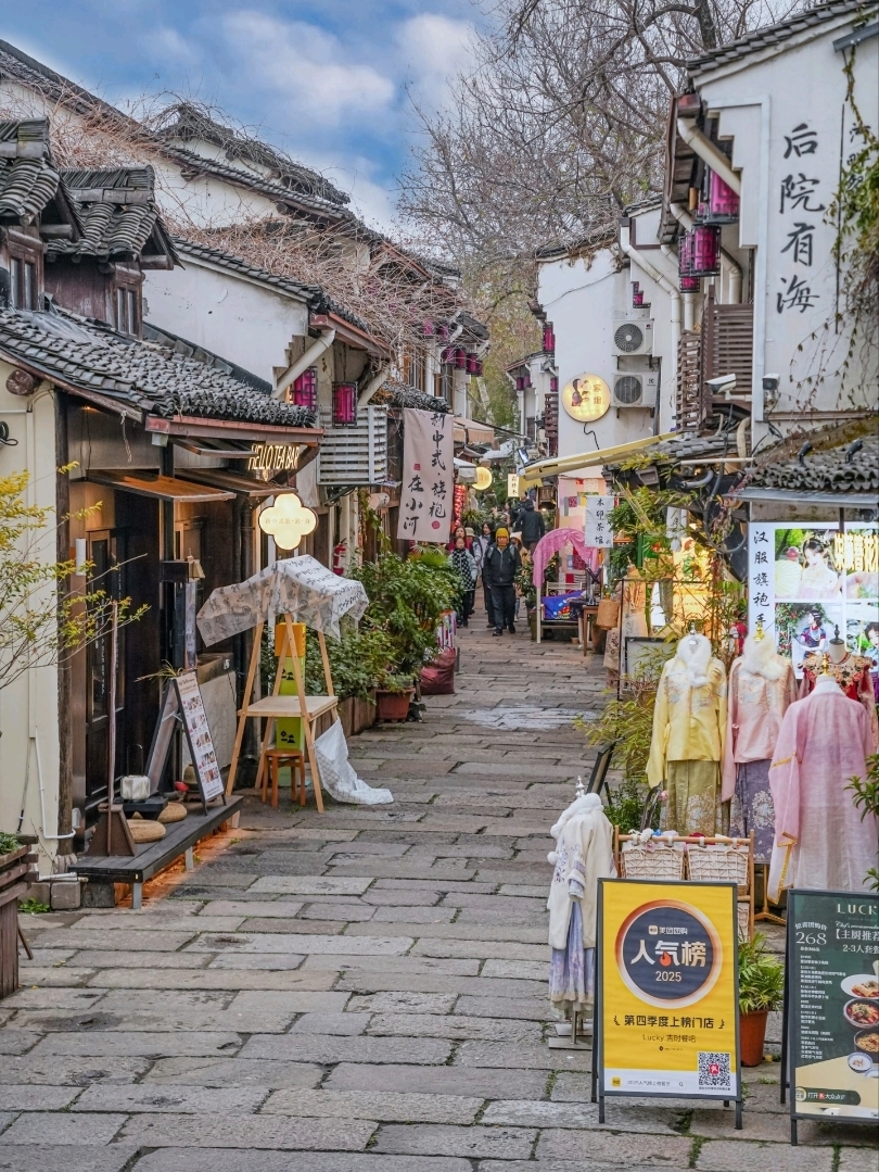 Escape the crowds at West Lake and take a leisurely stroll through the old town area, filled with:
🏯 Bronze temples
🏘️ Ancient houses
🛶 The Grand Canal (Beijing–Hangzhou)
🕯️ Lantern alleys
🌾 Riverside cafes with a laid-back vibe
Easy to walk, and every spot is incredibly photogenic 📸

📍 Main landmarks:
香积寺 Xiangji Temple
大兜路历史街区 Dadoulu Historic Street
小河直街 Xiaohe Straight Street
小河公园 Xiaohe Park
桥西历史街区 Qiaoxi Historic Street
丝联166创意园 Silian 166 Creative Park
拱宸桥 Gongchen Bridge
All located in the Grand Canal/Gongshu District. Search for the Chinese names to find them all ❤️

🚇 How to get there:
Take Metro Line 3 → Get off at 香积寺 (Xiangji Temple) Station → Exit C, then walk 8–10 minutes to enter the old town alley.
From there, follow the route and end at Gongchen Bridge comfortably.

🏙️ Citywalk route (takes 3–4 hours):
Xiangji Temple → Dadoulu → Xiaohe Straight Street → Xiaohe Park → Qiaoxi → Silian 166 → Gongchen Bridge

1) Xiangji Temple – 香积寺
A bronze temple with a shimmering copper glow.
Photo highlights:
✓ Twin pagodas
✓ Bronze walls
✓ Golden main hall
All free to enter!

2) Dadoulu Historic Street – 大兜路历史街区
A serene old town by the water.
✓ Tea shops
✓ Vegetarian restaurants (highly rated by bloggers)
✓ Jiangnan-style craft stores

3) Xiaohe Straight Street – 小河直街
An ancient alley with white walls and black-tiled roofs.
✓ Riverside shops
✓ Beautiful lanterns in the evening
✓ Classic Chinese-style photo spots

4) Xiaohe Park – 小河公园
A landmark of an old oil factory → renovated.
✓ Oil drum lanterns
✓ Red brick balconies
✓ Floating flower platforms
This spot offers a Japanese + industrial photo vibe.

5) Qiaoxi Historic Street – 桥西历史街区
A historic area from the Ming–Qing era.
✓ Umbrella, fan, and sword museums
✓ Traditional craft shops
✓ "Retro lantern wall" – a stunning photo spot

6) Silian 166 Creative Park – 丝联166创意园
An old silk factory → art community.
✓ Factory brick walls
✓ Beautiful cafes
✓ Art studios
This location is super hip + retro.

7) Gongchen Bridge – 拱宸桥
A landmark of the Grand Canal.
✓ Panoramic evening views
✓ Cool breezes by the water
✓ Stunning canal lights for photography.