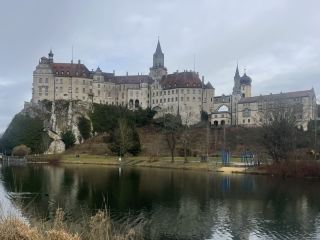 霍亨索倫城堡(Hohenzollernschloss)位於德國巴登-符騰堡州西南部的齊格馬林根(Sigmaringen)小鎮,坐落在多瑙河上游沿岸和施瓦本阿爾布山脈(Schwäbische Alb)邊緣,距斯圖加特約100公里,是德國南部多瑙河流域最具代表性的歷史城堡之一。城堡最早可追溯至1077年,是霍亨索倫家族施瓦本支系的重要祖居,與德國、法國乃至歐洲近代歷史密切相關。1944年晚期,納粹德國瀕臨失敗,法國維希政府在德國扶持下遷至齊格馬林根的霍亨索倫城堡,並在此設立名義上的流亡政權,成為第二次世界大戰末期一段頗具戲劇性的歷史插曲。民間還流傳著城堡地窖藏有霍亨索倫家族珍寶的傳說,但關於所謂“戰爭寶藏”或拿破崙戰爭戰利品祕藏,目前並無可靠歷史證據予以證實。