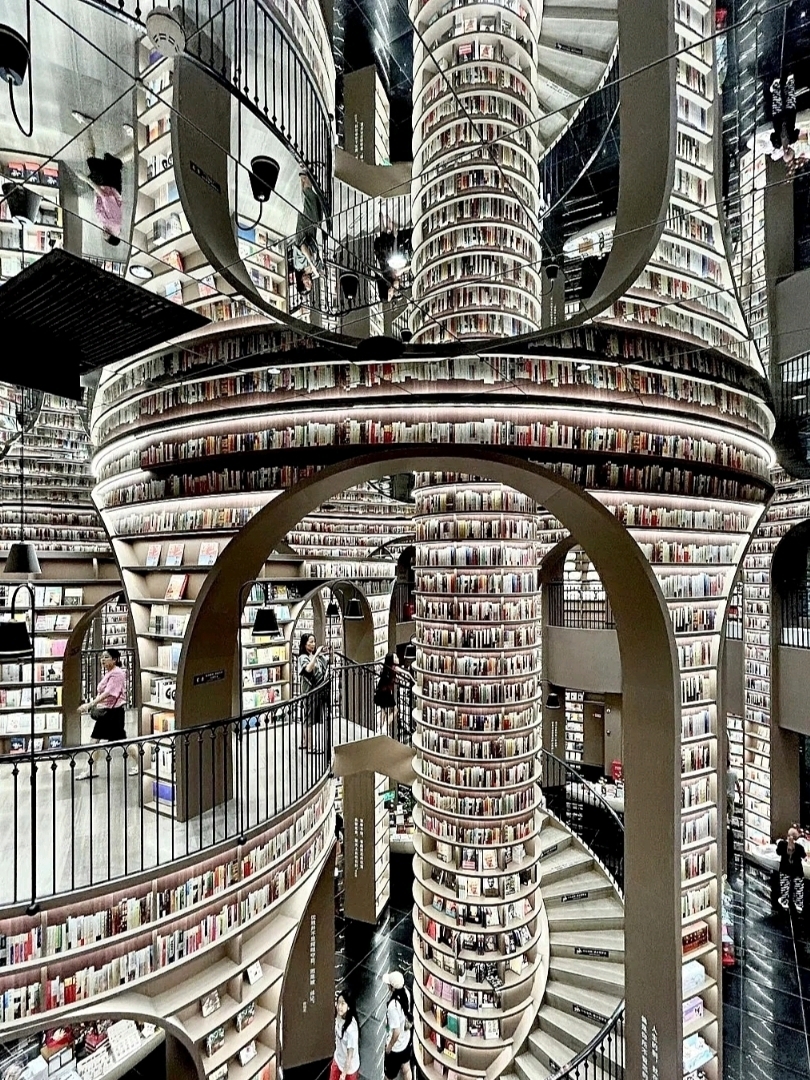 Today, I had the chance to check in at the Zhongshuge Bookstore, Rongchuang Mao branch. I was curious why so many people love taking photos there. Once I visited, I totally understood. The store is uniquely beautiful with its curved bookshelves. No matter how you take photos, they turn out great. The lighting is perfect, making portraits look flawless. However, it’s quite crowded, so you’ll need to find a good spot.

On the upper floor, you can get a full view of the entire store, making it easier to take photos. The lower floor is packed with books, and it’s fun to browse around. There are also quiet spots to sit and read. If you visit in the afternoon, it tends to be busier, but you can still find cozy corners to relax.

In summary, the store is truly beautiful, great for photos, and a pleasant place to hang out. Don’t set your expectations too high, but if you’re looking for stunning photo opportunities, it’s worth it.

📍 Location
Zhongshuge Bookstore – Chengdu Rongchuang Mao (成都·钟书阁 融创茂店)
Located in Wenjiang District, Chengdu, inside the Rongchuang Mao shopping mall. It’s easy to find.

🚇 How to get there
Metro → Get off at Lianghe Road Station (两河路站) and walk for 8–10 minutes.
Or take a taxi from downtown, which takes about 20–30 minutes.

💰 Costs
Free entry. Drinks in the store cost around 20–35 yuan.
Souvenirs/notebooks range from 20–60 yuan, depending on the type.