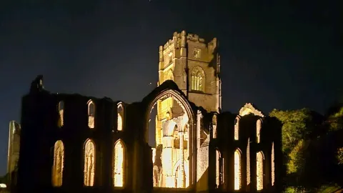 Historic ruins lit up at night — traveler post in Ripon