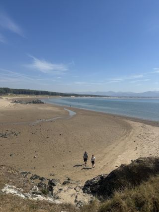 🌲🏖️⛰️ Llanddwyn Beach, Anglesey, Wales — where pine tree forest meets sea and mountains

If you want a beach that feels untouched and a little bit magical, this is it.

🌲The walk in
You start by walking through a pine tree forest. With well-marked paths and signs leading to the beach, all you have to do is bath in the forest pine and sea salt air. As the trees open up, you’ll be greeted by a long stretch of white sandy beach. 

🏖️The beach
This isn’t a packed, noisy beach. It’s a long coast with plenty of space for everyone. The water is calm, shallow and crystal clear with soft sand underneath, perfect for kids and beginner swimmers. Bring a paddle board or a kayak and enjoy. 

🗻The best part? Swimming with the Snowdonia mountains as your backdrop. It’s unreal. You’ve got forest behind you, mountains across the water, and nothing but nature around you. Bring a beach umbrella or tent though, there’s no shade except in the forest.

🔆The lighthouse on the outrock
At low tide you can walk out to the rocky outcrop with the old lighthouse at the end.
Along the way, you’ll find water coves and sandy beaches with picturesque spots to lay a towel and sunbathe. The water there is emerald and clear, it’s unreal. 

Check tide times before you go so you don’t get stranded out there.

📍What to know before you go

🚗 Parking: The nearest is Llanddwyn Beach Car Park and Cwningar Car Park. Both are small and fill up fast. Llanddwyn is closest but only 30 minutes free parking. For free all-day parking try Llyn Rhos-ddu Car Park, but it’s smaller and further away.

⛱️ Facilities: There are no cafes, shops, changing rooms, or bathrooms on site. Plan ahead. Bring plenty of food and water. Sometimes there’s a snack and ice cream truck in the car park, but don’t count on it.

🎒What to pack: Swimming gear, towels, change of clothes, beach umbrella/tent for sun shelter, sun protection, and remember to take your trash with you! 

This is an untouched nature spot where forest, sea, and mountain all meet. It takes effort to get there, but it’s 100% worth it. Parking is possibly the only fee you’ll pay. One of the most beautiful places you’ll ever see and experience and remember it for a long time.

 #northwales  #nationalpark  #nature  #uktrip  #travel2026  #beachlife  #wales  #roadtrip  #uktravel  #travel 
