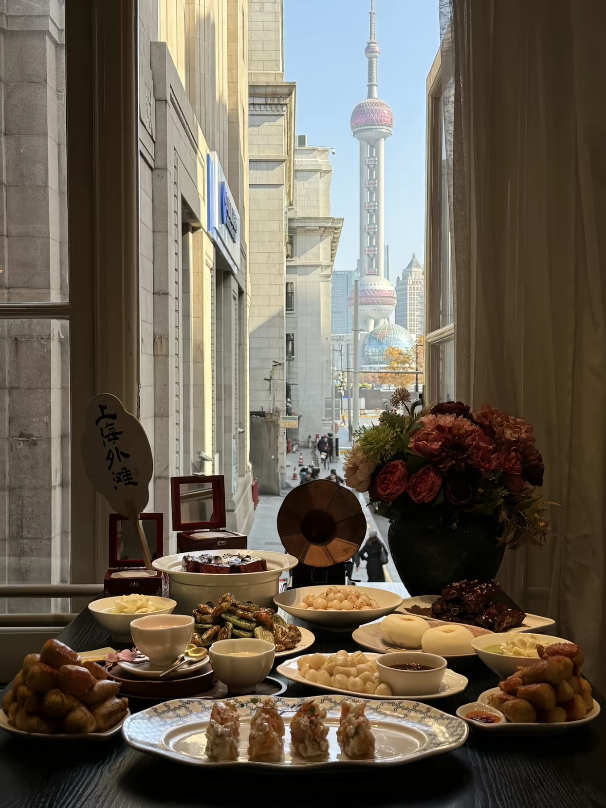 If you're visiting Shanghai and craving authentic local flavors but also want Instagram-worthy presentation, I highly recommend this spot! Located right along Nanjing Road, the window seats offer epic views of the iconic trio of skyscrapers over in Pudong. 🏙️

🍽️ Must-Try Menu:
· Gold-Dusted Braised Pork Ribs 🍖: Fall-off-the-bone tender meat in a juicy, perfectly balanced sweet and savory sauce. Absolutely obsessed!
· "Xie Bang" Stuffed Crab Claws 🦀: Crispy fried and packed with real crab meat. Dip it in the house-special chili sauce for ultimate satisfaction.
· Peony Matcha Pudding 🌸: Pure culinary art! A white floral pudding floating over a green tea sauce. Almost too pretty to eat.
· Dry Tangyuan with Osmanthus Sauce 🍡: Wonderfully soft and chewy, infused with the fragrance of traditional Chinese blossoms. Perfectly sweet and refreshing.

This is a fantastic spot that gives a modern twist to classic Shanghainese cuisine. Top-tier ingredients, gorgeous presentation, and a super convenient location. A definite must-try for anyone visiting Shanghai! 🥂💬

📍 Location: Waitan Jiayan, 2nd Floor, Nanjing Road Area, Shanghai