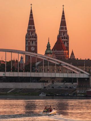 🇭🇺 Szeged, Hungary

Szeged is one of Hungary’s most charming cities, located in the country’s south on the banks of the Tisza River. It’s often called the “City of Sunshine” because it receives some of Hungary’s highest annual sunshine hours.

📍 Why visit Szeged?

Szeged is perfect if you enjoy:

· 🏛️ Historic architecture
· ⛪ Beautiful churches and squares
· 🌊 Riverside walks
· ☕ Cafés and relaxed city life
· 🌳 Parks and outdoor spaces
· 🍲 Hungarian food and paprika
· 🎭 Festivals and cultural events

⭐ Top places to visit

1. Votive Church of Szeged (Szegedi Dóm)
The city’s most famous landmark. Its twin towers dominate Dóm Square, one of Hungary’s most beautiful urban squares.

2. Dóm Square
A spectacular open square surrounded by historic buildings. In summer, it hosts the famous Szeged Open-Air Festival.

3. Reök Palace
A stunning Art Nouveau building designed by architect Ede Magyar. Its colorful façade makes it one of Szeged’s most photographed buildings.

4. Szeged Synagogue
One of the most impressive synagogues in Hungary, famous for its beautiful interior, stained glass and ornate dome.

5. Tisza River 🌊
Take a leisurely walk along the river, especially around sunset. Riverside cruises and boat trips can also be available seasonally.

6. Széchenyi Square
A large green central square surrounded by elegant historic buildings. It’s a pleasant place for a relaxed walk.

7. Móra Ferenc Museum
A good choice for history, archaeology, art and local culture.

8. Anna Thermal Bath ♨️
A historic thermal bath where you can relax in thermal pools and enjoy spa facilities.

9. Szeged Zoo 🦁
A large zoo on the outskirts of the city, particularly suitable if you’re traveling with children.

10. Újszeged
The quieter area across the Tisza, with parks and the Erzsébet Grove, ideal for walking and relaxing.

🚆 How to get there

From Budapest, Szeged is very easy to reach by train.

· 🚆 Budapest → Szeged: roughly 2–2.5 hours
· 🚗 By car: roughly 2 hours, depending on traffic
· 🚌 Long-distance buses are also available.

Szeged is also relatively close to Serbia and Romania, making it interesting as part of a Central European road trip.

🌤️ Best time to visit

May–June: 🌸 Excellent weather and pleasant sightseeing
July–August: ☀️ Warm, lively and festival season
September: 🍂 Comfortable temperatures and fewer crowds
December: 🎄 Christmas atmosphere and festive markets

For a comfortable sightseeing trip, May–June or September would be my choice.

🗓️ How many days?

1 day: Main sights and city center
2 days: Ideal for a relaxed visit
3 days: Add thermal baths, museums, food experiences and nearby attractions

Sunset beside the Tisza River is especially beautiful. 🌅

Szeged is a great choice if you want a quieter, more relaxed Hungarian experience rather than the busy atmosphere of Budapest.
