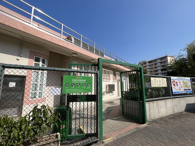 車來車往交通迴旋處旁邊嘅一個硬地足球場