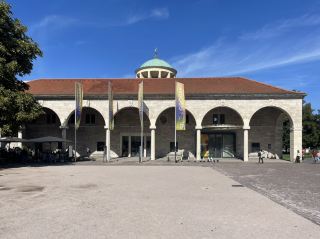 斯圖加特藝術建築(Kunstgebäude Stuttgart)位於德國斯圖加特市中心的宮殿廣場旁,是這座城市最具代表性的藝術文化建築之一。它建於1912年至1913年,由著名建築師特奧多爾·菲捨爾(Theodor Fischer)設計,融合了新古典主義和新藝術運動風格。建築最引人注目的特點是中央巨大的圓頂以及頂部的金色鹿雕像,已成為斯圖加特城市景觀中的標誌。斯圖加特藝術建築最初作為藝術展覽場所,為符騰堡藝術協會(Württembergischer Kunstverein)等藝術機構提供展示空間。20世紀以來,這裡曾舉辦眾多現代藝術和先鋒藝術展覽,在德國藝術發展史上具有重要地位。