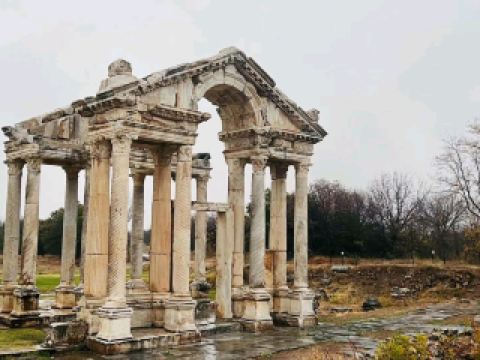 #winterescape Step into Ancient Grandeur at Aphrodisias 🏛️🌧️  
Aphrodisias Ancient City is a jaw-dropping open-air museum where ancient ruins, artistic masterpieces, and lush landscapes blend together. Wander through marble streets sprinkled with history—this is one of Turkey’s unsung archaeological gems, especially atmospheric on a cloudy or rainy day!

Your route: Enter from Geyre Belediyesi for easy access and start at the grand Tetrapylon gate—strike your first photo here, framing the dramatic pillars against moody skies. Follow the old marble paths to the Stadium, one of the world’s best-preserved, and snap wide-angle shots of the sweeping arches. Next, meander to the Aphrodisias Museum itself (right by the ancient city), where intricate statues and relics are displayed up close; from here, the nearby Temple of Aphrodite is a must, ideal for capturing close-up architectural details (especially with raindrops clinging to the old stone). Don’t skip the theater—take a panoramic shot from the top tier for a real “lost in time” vibe!

Must-dos: 
- Take a slow walk through the Agora for classic “ruins among trees” photos.
- Document building details and dramatic ruins (zoom in for statues and column carvings).
- Pause under any remaining arches for that perfect “framed in stone” portrait.

Practical tips:
- Bring a raincoat and sturdy shoes—the stones get slippery when wet, making umbrellas a hassle.
- Open daily 8:30 AM–7:00 PM; early mornings = better light and fewer people.
- There’s limited shelter, so aim for quick breaks if showers intensify.

Key precautions: 
- Watch your step on uneven paths, especially in rainy weather.
- Mind the museum’s indoor humidity—be gentle with your photo gear.

#Aphrodisias #TurkeyTravel #AncientRuins #CulturalHeritage #PhotoSpots