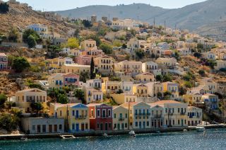 Symi — The Greek Island Town Where Neoclassical Mansions Rise From the Harbor and Sponges Built a Fo