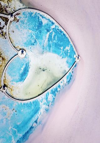 The stunning scenery of the colorful salt lake reflecting the snow-capped mountains